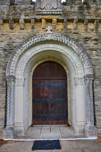 Daytime view of the grand, intricately carved entrance to the historic Bishop Simon Brute College Chapel in Indianapolis, echoing timeless religious reverence and architectural majesty.