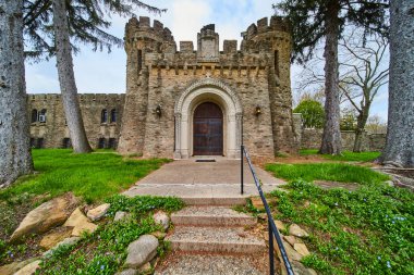 Springtime view of the historic Bishop Simon Brute College entrance in Indianapolis, a medieval castle symbolizing heritage and strength. clipart