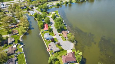 Varşova, Indiana 'da bir göl kenarındaki huzurlu bir banliyö manzarası, bereketli manzaralar ve deniz manzaralı evler.