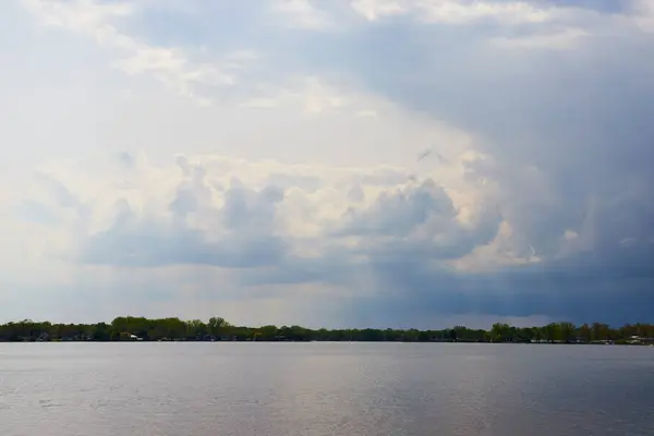 stock image Dramatic clouds and serene lake at Winona Lake, Indiana, hint at an approaching storm.