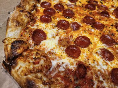 Cızırdayan bir pepperonili pizzanın yakın çekimi. Çıtır çıtır ve köpüklü peynirli. Fort Wayne ziyafeti için mükemmel..