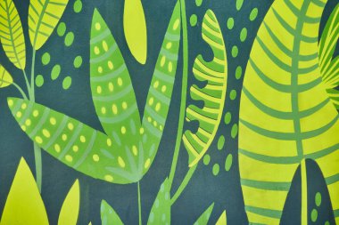 Kalın yeşillikler ve sarılar içinde birbirine dolanmış tropikal yaprakların canlı duvar resmi, Fort Wayne 'deki sanat eserlerini yakalıyor..