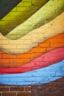 Fort Wayne 'de canlı geometrik duvar resmi, desenli tuğla bir duvarda renkli şehir sanatı sergileniyor..