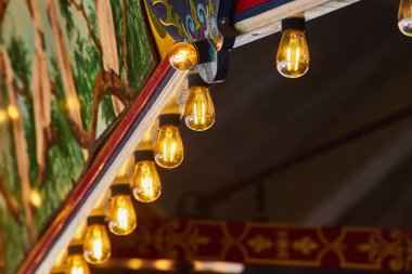 Sanatsal duvar resmi ve sıcak filaman ampulleri olan klasik kafe ambiyansı, sıcacık, bohem bir ortam..