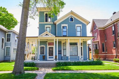 Fort Wayne 'deki büyüleyici mavi banliyö evi, yemyeşil, canlı Amerikan ailesi.