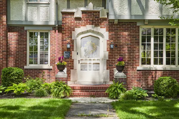 stock image Traditional brick home in South Wayne Historic District, Fort Wayne, with vibrant floral entryway.