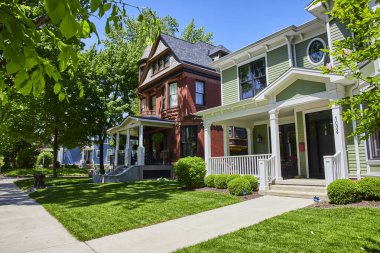 Fort Wayne 'de büyüleyici bir banliyö caddesi tarihi Viktorya dönemi ve modern evleri berrak mavi gökyüzü altında.