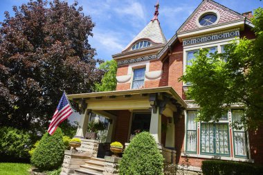 Fort Wayne, Indiana 'da Victoria tarzı bir ev, Amerikan bayrağıyla süslenmiş, tarihi bir zarafet ve ulusal gurur sergiliyor..