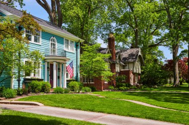 Fort Wayne 'deki Idyllic banliyö sokağı, canlı turkuaz ev Amerikan bayrağı ve yemyeşil.
