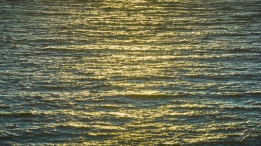 Altın güneş ışığı okyanus dalgaları üzerinde dans eder, Samuel H Boardman State Sahne Koridoru, Brookings, Oregon 'daki Arch Rock yakınlarında büyüleyici bir parıltı bırakır. Bu sakin hava görüntüsü, doğal huzuru yakalar.
