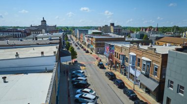 Huntington, Indiana şehir merkezindeki canlı hava manzarası, tarihi tuğla binalar, hareketli ana cadde ve açık, parlak bir gökyüzü altında ikonik adliye binası. Küçük kasabayı canlandırmak için mükemmel.