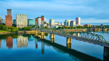 Portland, Oregon 'un havadan görünüşü Hawthorne Köprüsü' nü ve şehir merkezinin canlı ufuk çizgisini vurguluyor. Yumuşak ışıklandırma Willamette Nehri 'nin sakin yansımalarını güçlendiriyor, kentsel dinamizmi harmanlıyor.