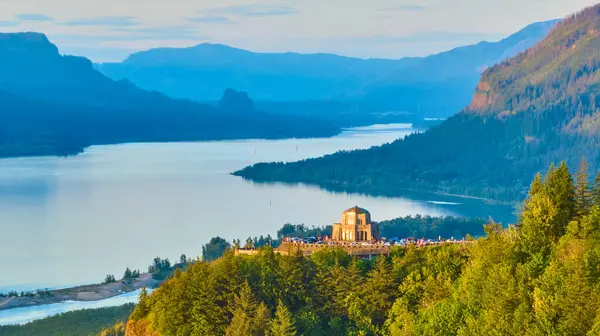 stock image Aerial view of the stunning Columbia Gorge during golden hour, featuring the majestic Vista House at Crown Point in Corbett, Oregon. Scenic river valley with lush forests and misty mountains in the