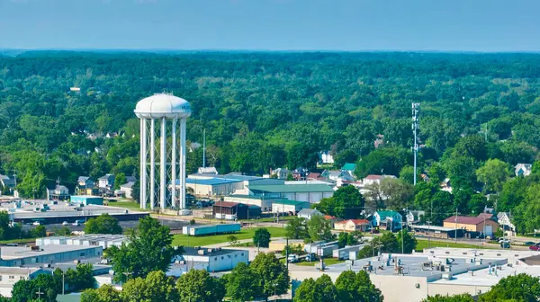 Huntington, Indiana 'nın havadan görünüşü, canlı bir şehir manzarasını yemyeşil olarak gösteriyor. Önde gelen beyaz su kulesi üzerinde HUN yazılı, toplumsal gelişimi doğal ile harmanlıyor.