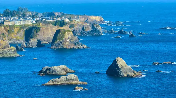 stock image Aerial view of Brookings coastal landscape at Harris Beach State Park, Oregon. Rugged cliffs and serene ocean with a small town nestled on the cliffs. Perfect for travel, real estate, and conservation