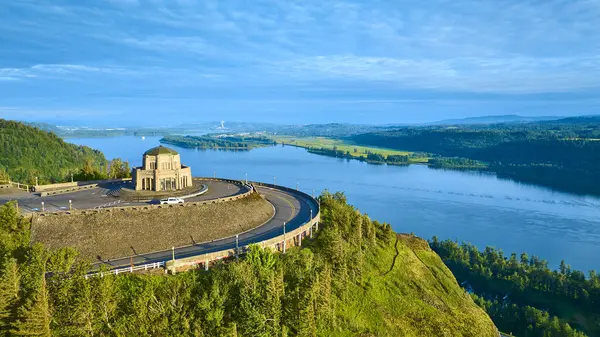 stock image Aerial view of Vista House at Crown Point, Oregon, bathed in morning light, overlooking the Columbia Gorge with its winding river and lush hills. Perfect for travel, nature, and tranquility-themed