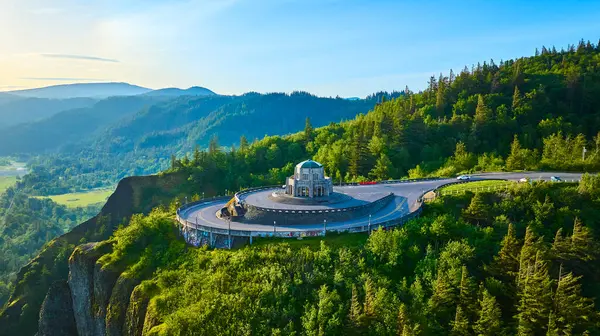 stock image Aerial view of Vista House at Crown Point during golden hour, surrounded by the lush Columbia River Gorge in Oregon. This historic observatory, with its scenic roads and vibrant landscape, is a nature