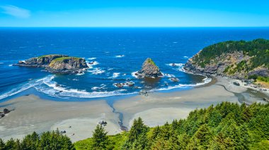 Samuel H. Boardman Eyalet Sahili Koridoru, Oregon 'daki Balina Kafa Sahili' nin havadan görünüşü. Özellikleri bereketli adacıklar, piramit şeklinde bir kaya, ve bir nehirle buluşan sinsi bir sahil, evcilleştirilmemiş güzelliği sergiliyor.