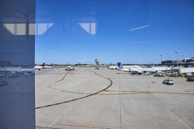 Lively Minneapolis airport scene with a United Airlines plane at the gate, bustling ground crew, and a prominent control tower under a clear blue sky ideal for travel and aviation themes. clipart