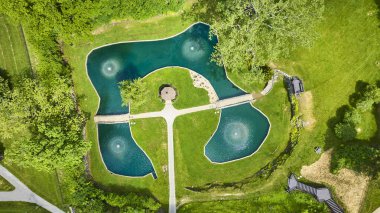 Huntington, Indiana 'daki Memorial Park' taki Batık Bahçeler 'in havadan görüntüsü. Çeşmeler ve yemyeşil ile çevrili merkezi bir çardağı olan büyüleyici yonca şekilli bir gölet huzurlu bir geri çekilme sunuyor..