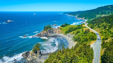 Brookings, Oregon 'daki çarpıcı Arch Rock' ın hava görüntüsü. Samuel H. Boardman Eyalet Sahne Koridoru 'nun güzelliğini canlı renklerle, yemyeşil ve büyüleyici Pasifik manzarasıyla yaşayın.