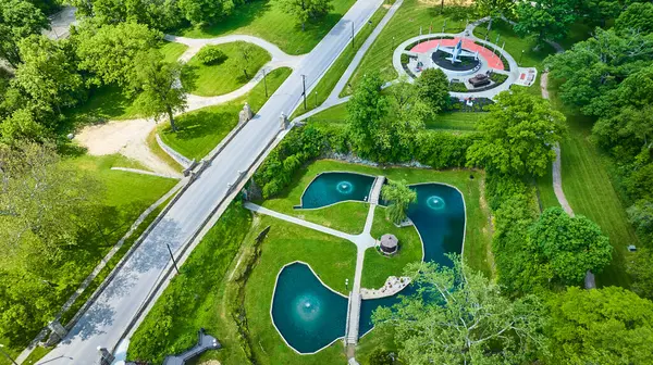 stock image Aerial view of Memorial Park in Huntington, Indiana, showcasing the Charters of Freedom monument, lush Sunken Gardens, and clover-shaped ponds, all connected by neat pathways within a vibrant, green