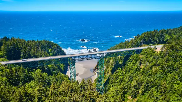 stock image Aerial view of Thomas Creek Bridge, Oregons tallest, spanning a deep canyon in Samuel H. Boardman State Scenic Corridor. Nestled among lush forests with the blue ocean beyond, it showcases natures