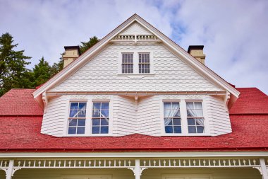 Karmaşık ahşap işçiliği ve canlı kırmızı çatısı olan büyüleyici Viktorya tarzı bir ev Floransa, Oregon 'da bulutlu bir gökyüzüne karşı çekildi. Miras, muhafaza ve mimari temalar için mükemmel