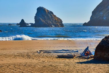 Oregon 'daki Harris Beach Eyalet Parkı' nda sakin bir öğleden sonra. Altın kumlar, engebeli kaya oluşumları ve konforlu bir kamp ateşi Batı Yakası 'nda rahatlama ve deniz macerası için mükemmel bir sahne yaratır..