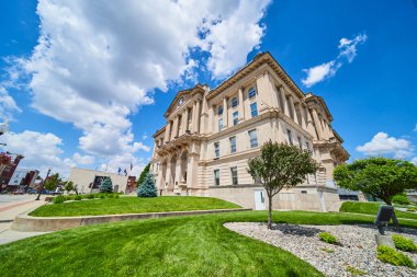 Indiana şehir merkezindeki tarihi Huntington Eyaleti Yüksek Mahkemesi göz kamaştırıcı bir mavi gökyüzünün altında duruyor. Klasik mimarisi, güçlü sütunları ve merkezi saat kulesi,