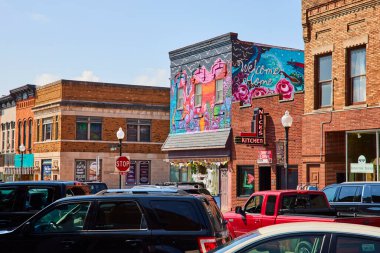 Huntington, Indiana 'daki küçük şehir manzarasında canlı bir hoş geldin duvar resmi, klasik tuğla binalar ve Nicks Kitchen var. Topluluk temaları, sanat etkileri ve yerel temalar için mükemmel