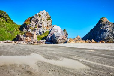 Stunning midday view of rugged rock formations and sandy beach at Harris Beach State Park, Brookings, Oregon. Perfect for adventure, geology, or nature themes. Pristine landscape ideal for travel and clipart