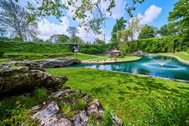 Indiana 'daki Huntingtons Batık Bahçeleri' nde sakin bir gündüz vaktidir. Parlak bir gölet, büyüleyici bir taş köprü ve tuhaf bir çardağı vardır. Emlak, peyzaj ya da boş zaman hizmetleri pazarlamak için mükemmel.