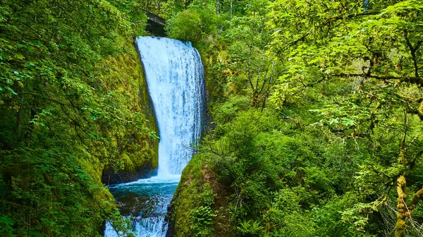 stock image Aerial view of Bridal Veil Falls in Columbia Gorge, Oregon. The powerful waterfall cascades amidst lush greenery, creating a serene and vibrant scene perfect for promoting travel, nature, and outdoor