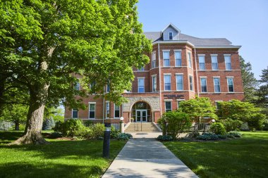 Indiana 'daki Huntington Üniversitesi' nin görkemli kırmızı tuğla binası olgun ağaçlar ve iyi korunmuş çimlerle bembeyaz pencereli ve taş sütunlu klasik mimari sergileniyor.