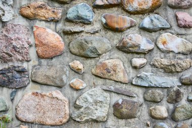 Huntingtons Batık Bahçeleri, Indiana 'da dokulu taş bir duvarın yakın çekimi. Betona gömülü taşların çeşitli renkleri ve şekilleri doğal güzelliği ve dayanıklılığı sergiliyor. Tasarım için ideal.