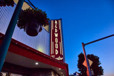 Brookings, Oregon 'daki Redwood Tiyatrosu' nda klasik Amerikan gece hayatının cazibesini yaşayın. Alacakaranlık gökyüzüne karşı aydınlatılmış tabela nostalji ve tarihi sinema büyüsünü çağrıştırıyor..