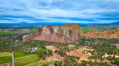 Terrebonne, Oregon 'daki Smith Rock State Park' ın hava manzarası dramatik kaya oluşumları, geniş vadiler ve dolambaçlı bir nehir. Seyahat, macera ve doğa temaları için mükemmel..