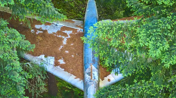 stock image Aerial view of an abandoned, weathered pipeline cutting through dense evergreen forest, highlighting the clash of nature and industry. Captured near Portland, Oregon, this image evokes themes of