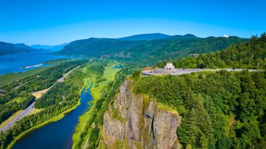 Crown Point, Oregon 'daki Vista House' un havadan görünüşü Kolombiya Boğazı 'na bakan bir uçurumun tepesine tünemişti. Yoğun ormanlardan oluşan panoramik manzaraların ve açık mavi gökyüzünün altında dönen bir nehrin tadını çıkar..