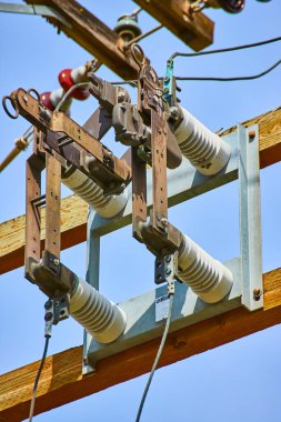 Oregon 'da bir elektrik direğinde açık mavi gökyüzüne karşı yüksek voltajlı şalter. Karmaşık elektrik mühendisliği detayları gösteriliyor. Endüstriyel altyapıyı resmetmek için mükemmel.