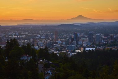 Portland üzerinde gün doğumu, arka planda muhteşem Hood Dağı ile yemyeşil tarafından çerçevelenmiş şehir manzarasını yakalar. Kentsel büyüme ve doğal güzelliğin çarpıcı bir karışımı. Temalar için mükemmel