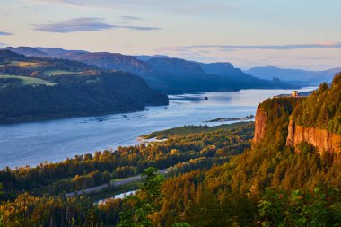 Columbia River Vadisi 'nde altın saat, yemyeşil ve yuvarlanan tepeler sergileniyor. Corbett, Oregon 'daki Crown Point' teki Vista House 'dan görüntü. Sakin nehir gökyüzünün renklerini yansıtıyor, mükemmel.