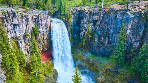 stock image Aerial view of Tumalo Falls in Deschutes National Forest, Oregon. Majestic waterfall cascades into a serene pool, surrounded by lush forest and rugged cliffs. Breathtaking natural beauty ideal for