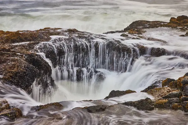 stock image Experience the raw beauty of Thors Well in Oregon. Waves cascade over rugged rocks, creating a mesmerizing coastal scene. Perfect for themes of natural power and soothing ocean landscapes.