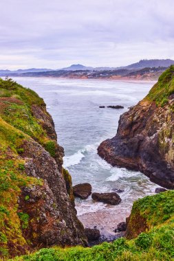 Dramatik uçurumlar ve çalkantılı denizler Newport, Oregon 'daki sakin Yaquina Baş Feneri ile buluşuyor. Bu çarpıcı kıyı manzarası Kuzeybatı Pasifik 'in ham güzelliğini ve gücünü yakalıyor.