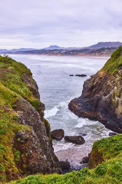 stock image Dramatic cliffs and turbulent seas meet the serene Yaquina Head Lighthouse in Newport, Oregon. This stunning coastal landscape captures the raw beauty and power of the Pacific Northwest, ideal for