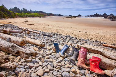 Oregon, Seal Rock 'ta kayalıkların ve taşların üzerinde dinlenen yıpranmış botlar sakin bir kıyı anını yakalıyor. Kıyıya gidenler ve kayalık çıkıntılar batı sahil şeridinin sakin ve vahşi güzelliğini arttırır.