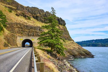 Columbia Vadisi, Washington 'dan geçen yol kayalık yamaçlara oyulmuş bir tünele çıkıyor. Doğayla baş döndürücü bir kontrast, seyahat, turizm ve çevre kampanyaları için mükemmel..