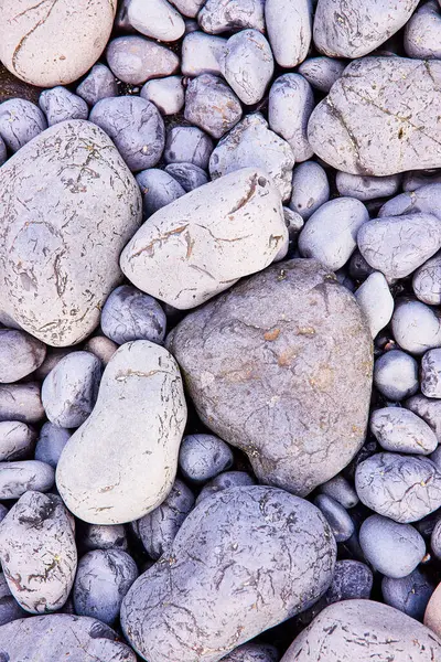 stock image Smooth, weathered stones in muted gray and blue hues, rich with texture and natural patterns, captured at Yaquina Head in Newport, Oregon. Perfect for themes of stability, nature, and geological